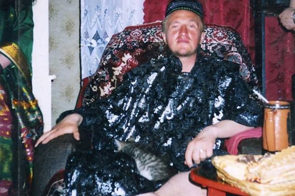 Photo of Konstantin Rudnev, leader of the Ashram Shambala sect, seated with a cat.