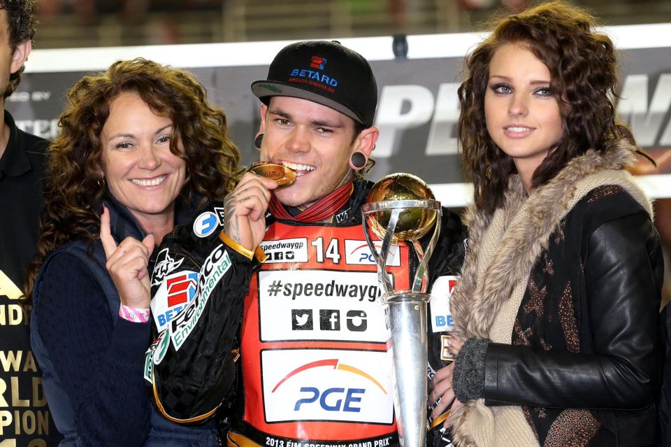 Speedway racer with family and trophy.