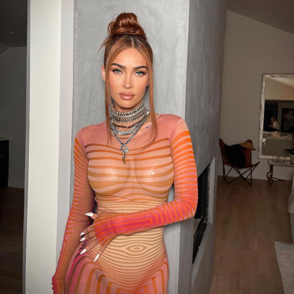 Megan Fox in a sheer, striped dress and layered necklaces.