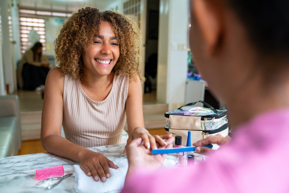 Woman smiling while getting a manicure.