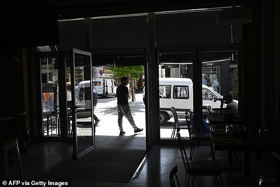 Local residents stand outside a closed bar during a massive power cut in Vigo, northwestern Spain, on April 28, 2025. A massive power cut a massive power cut affects the whole of the Iberian Peninsula and part of France on April 28, 2025, according to Portuguese electricity network operator REN. (Photo by MIGUEL RIOPA / AFP) (Photo by MIGUEL RIOPA/AFP via Getty Images)