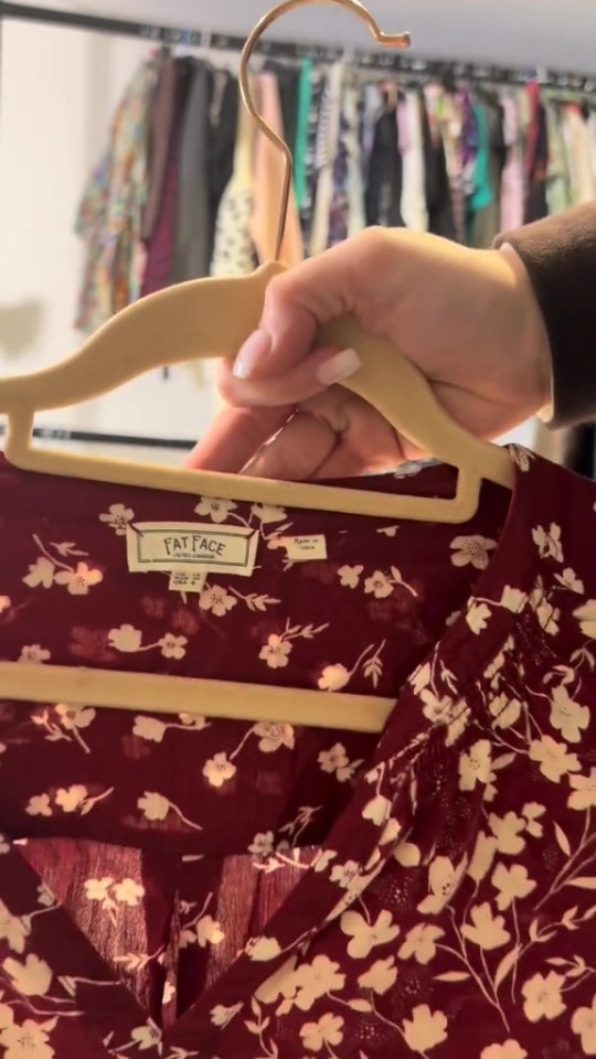 Red floral Fat Face blouse on a hanger.