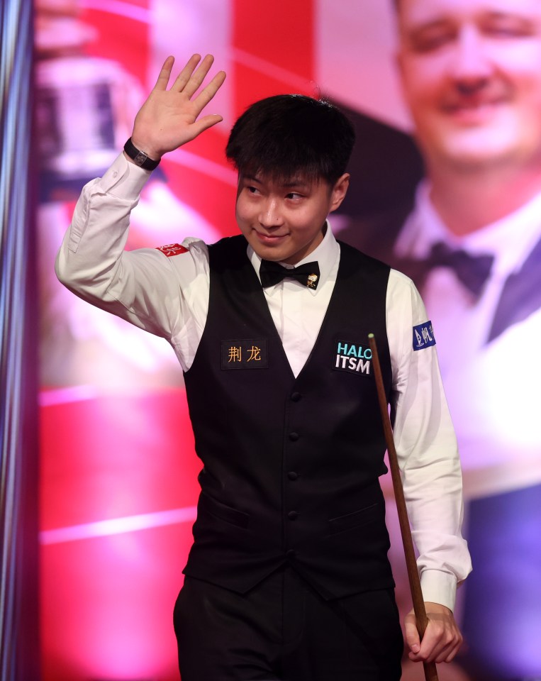 Zhao Xintong of China waves to the audience at a snooker match.