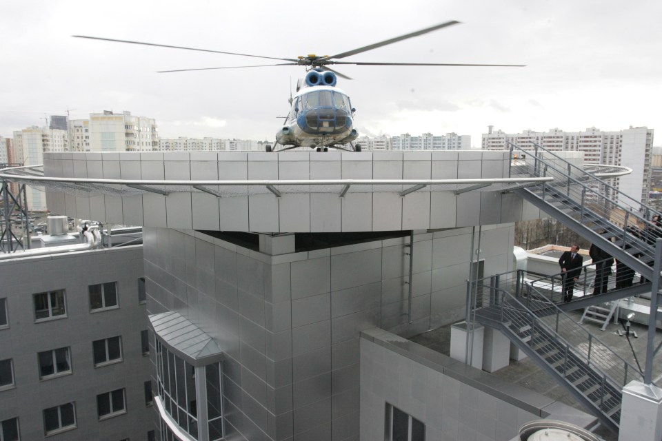 Helicopter landing on a rooftop helipad.