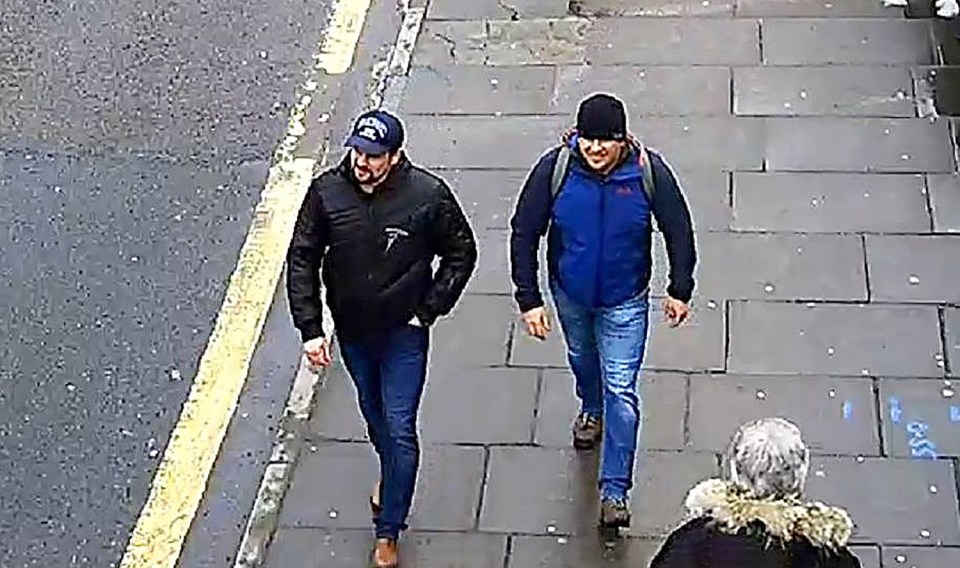 Surveillance image of two men walking down a sidewalk.
