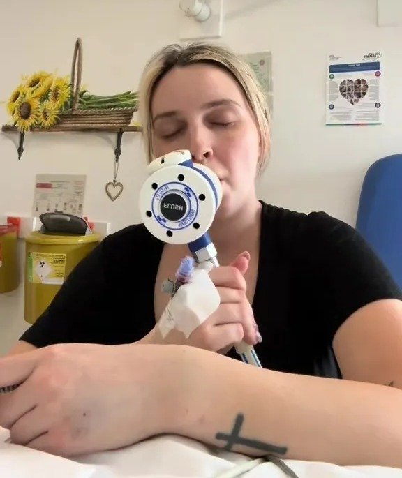 Woman in hospital using incentive spirometer.