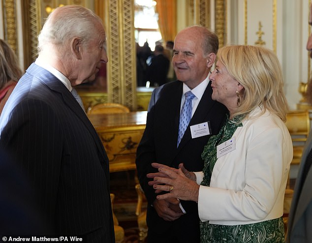 King Charles speaks with Alistair and Heather James, the parents of the late broadcaster Deborah James, during a reception in Buckingham Palace