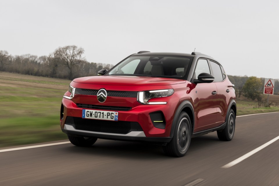 Red Citreon e-C3 driving on a road.