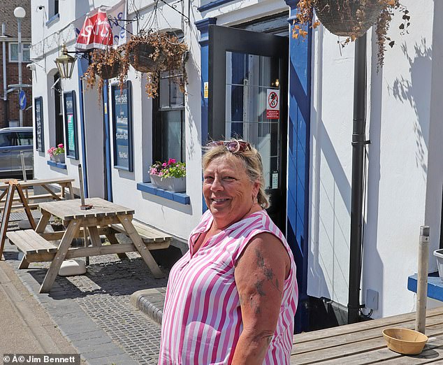 Pictured: Julie Evans, 65, who runs the Five Bells pub in the centre of the beleaguered village