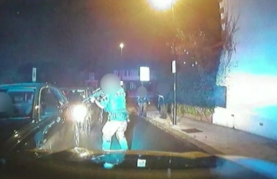 a group of people are standing on the side of a street at night .