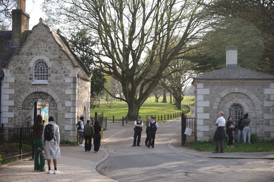 Police officers at the entrance to a park following a water incident.