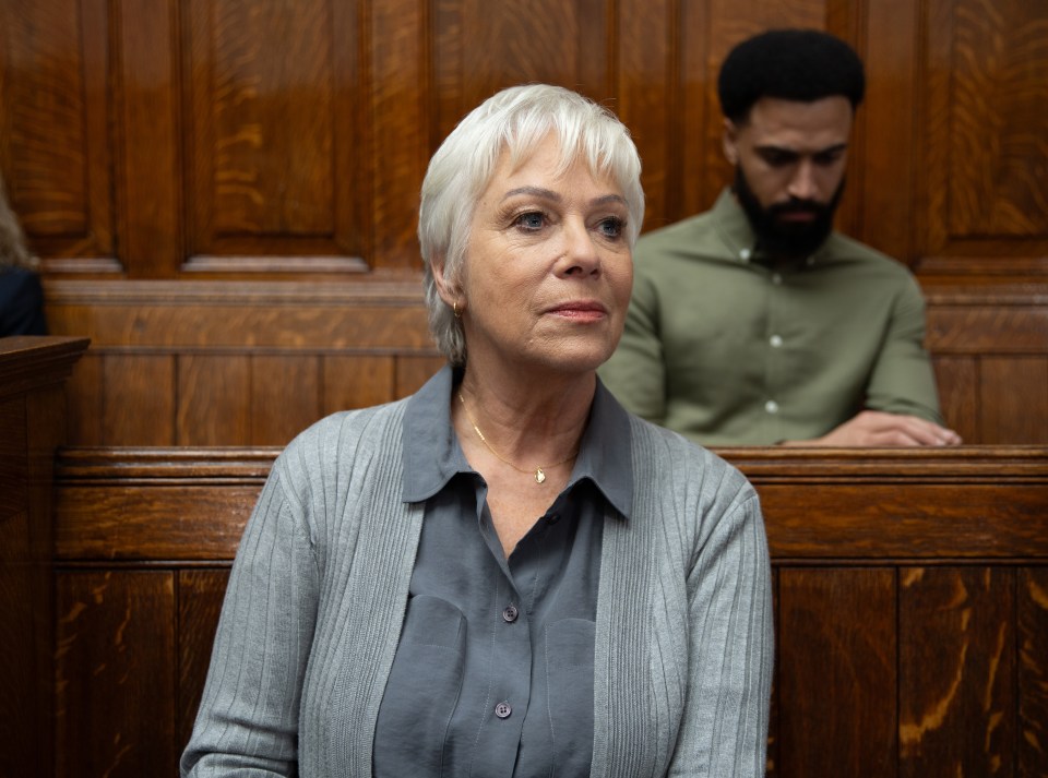 A woman sits on a jury, looking to her right.