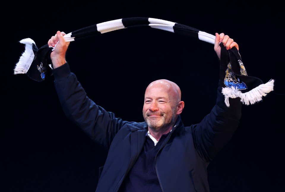Alan Shearer holding up a Newcastle United scarf at a trophy parade.