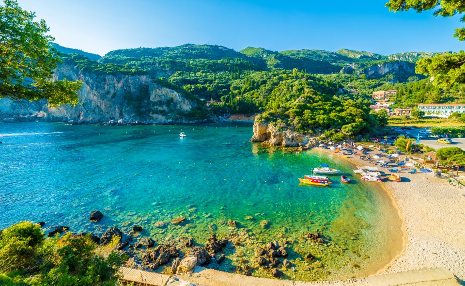 Paleokastritsa beach in Corfu, Greece, with boats and clear water.