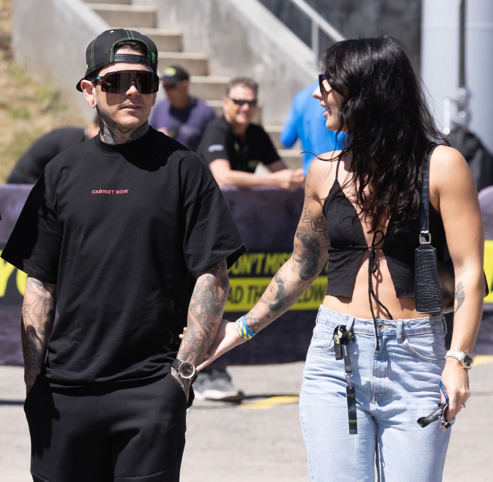 A tattooed couple holding hands.