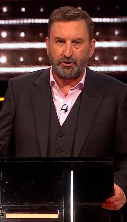 A man in a suit at a podium.