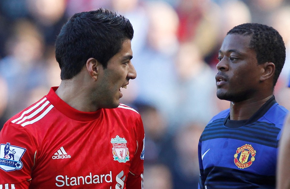 Luis Suárez and Patrice Evra facing each other during a soccer match.