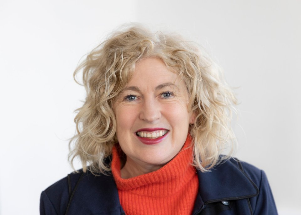 Portrait of a smiling woman with blond curly hair.