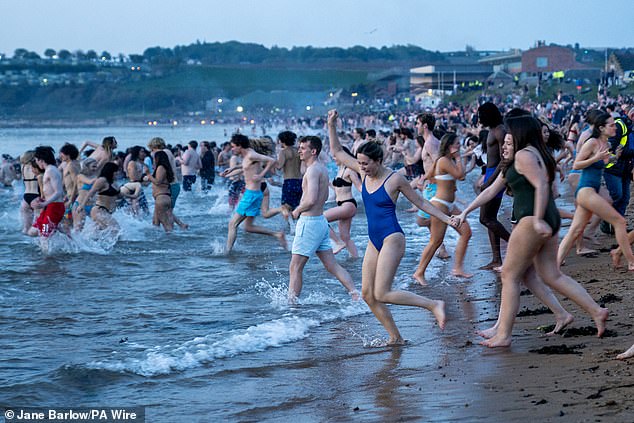 Hundreds of students run into the water on the East Sands in St Andrews, Fife, this morning