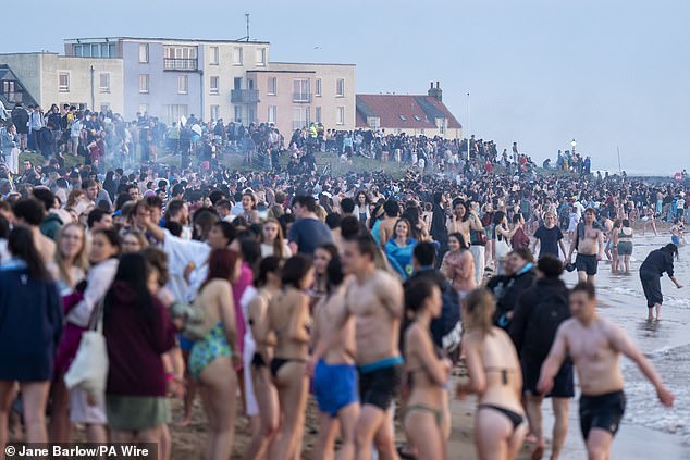 Hundreds of students go into the water on the East Sands in St Andrews, Fife, this morning