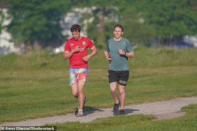 Joggers running in the bright morning sunshine on Wimbledon Common in London today