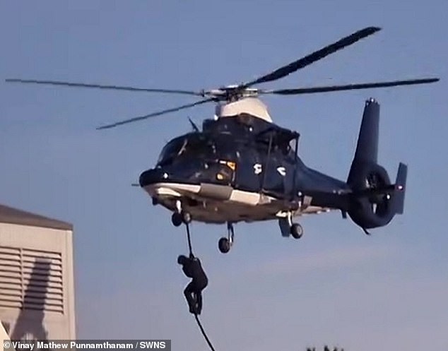 Ropes were dropped from both choppers before six figures, wearing black clothing bearing a similarity to military fatigues, took it in turns to abseil down them and onto a nearby roof