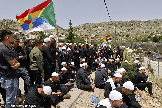 Druze men demonstrate in solidarity with the Syrian Druze community near the border barrier in the village of Majdal Shams in the Israeli-annexed Golan Heights on April 30, 2025