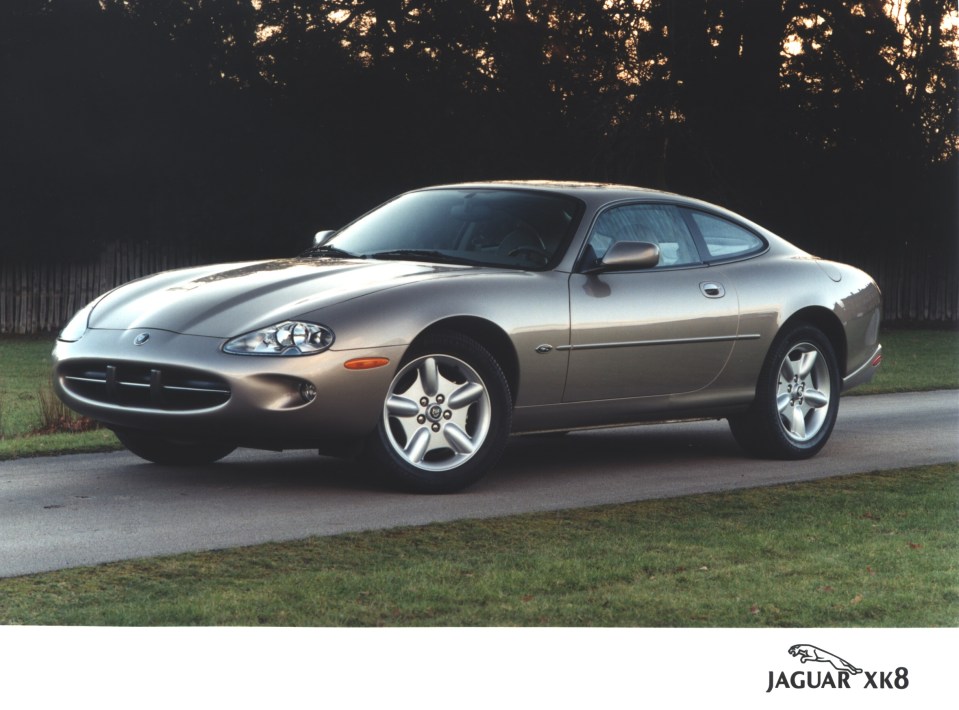 Silver Jaguar XK8 coupe parked on a driveway.