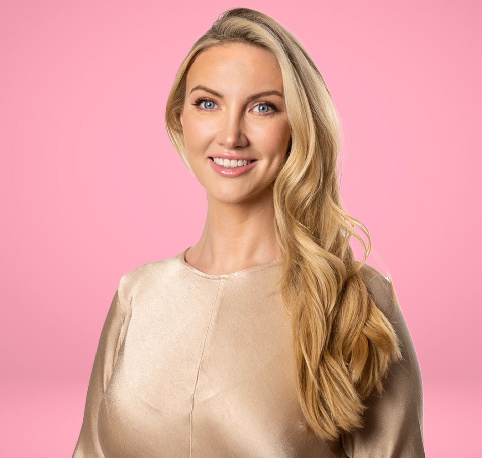 Portrait of a smiling woman with long blonde hair wearing a gold top against a pink background.
