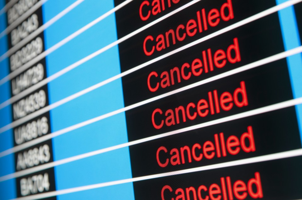 Airport departures board showing multiple cancelled flights.