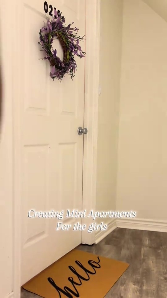 Door to a teenage daughter's apartment with a purple wreath and "hello" mat.