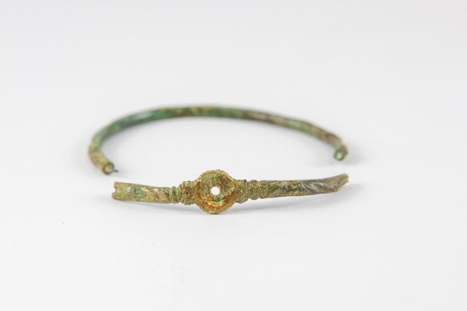 Broken bronze bracelet with a central disc.