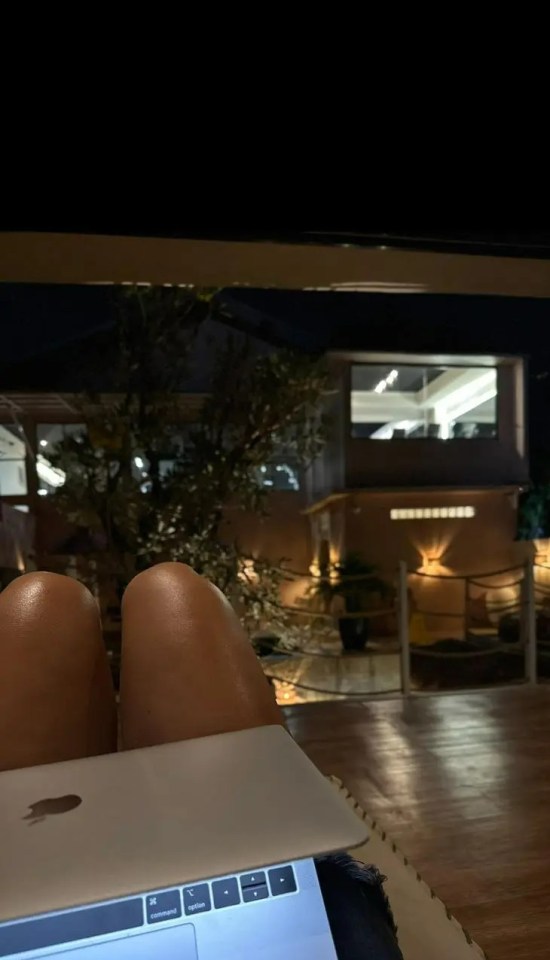 Person working on a laptop outdoors at night.