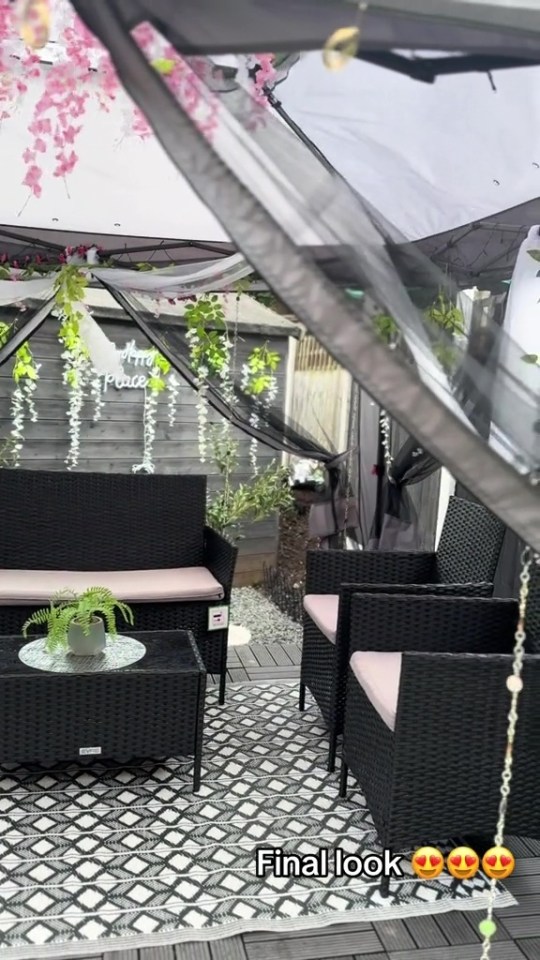 Decorated garden patio with black wicker furniture.