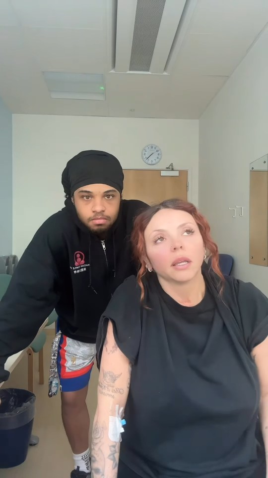 Jesy Nelson in a hospital room with a man, receiving medical treatment.