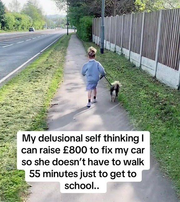 A child walking a dog on a sidewalk next to a road.