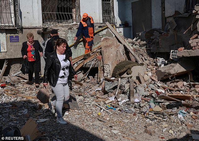 In March British intelligence claimed Russia has suffered the largest troop losses since World War Two during its invasion. Pictured: Residents are seen at the site of the apartment building hit by a Russian drone strike