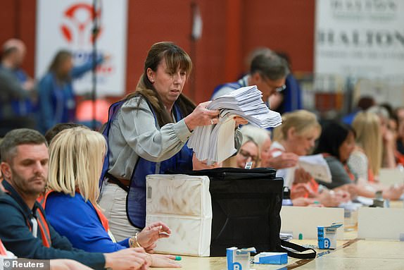 Votes are taken out of a ballot box for counting on the day of the Runcorn and Helsby by-election at Halton Stadium in Widnes, Britain, May 1, 2025. REUTERS/Phil Noble