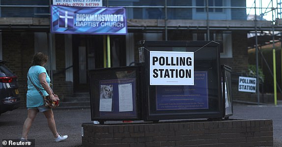 A woman walks past a polling station located in a church in Rickmansworth, Britain, May 1, 2025. REUTERS/Suzanne Plunkett