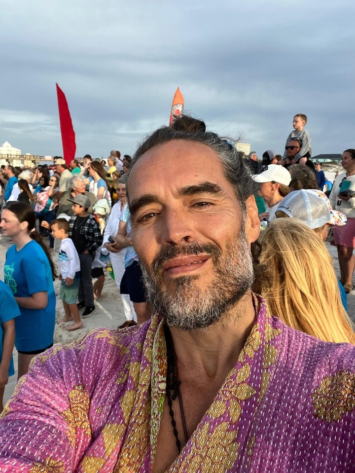 Russell Brand at a beach gathering.