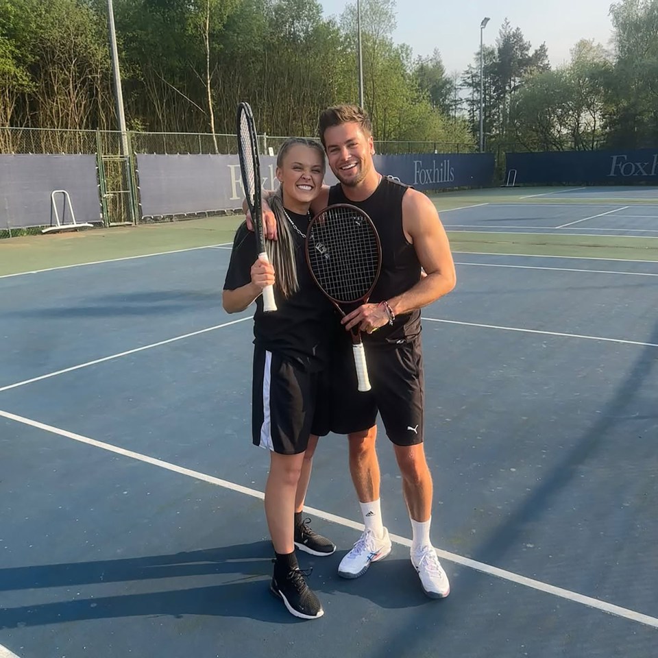 Two people holding tennis rackets on a tennis court.