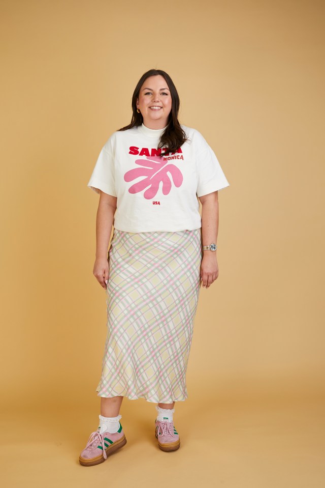 Woman wearing a Santa Monica t-shirt and plaid skirt.