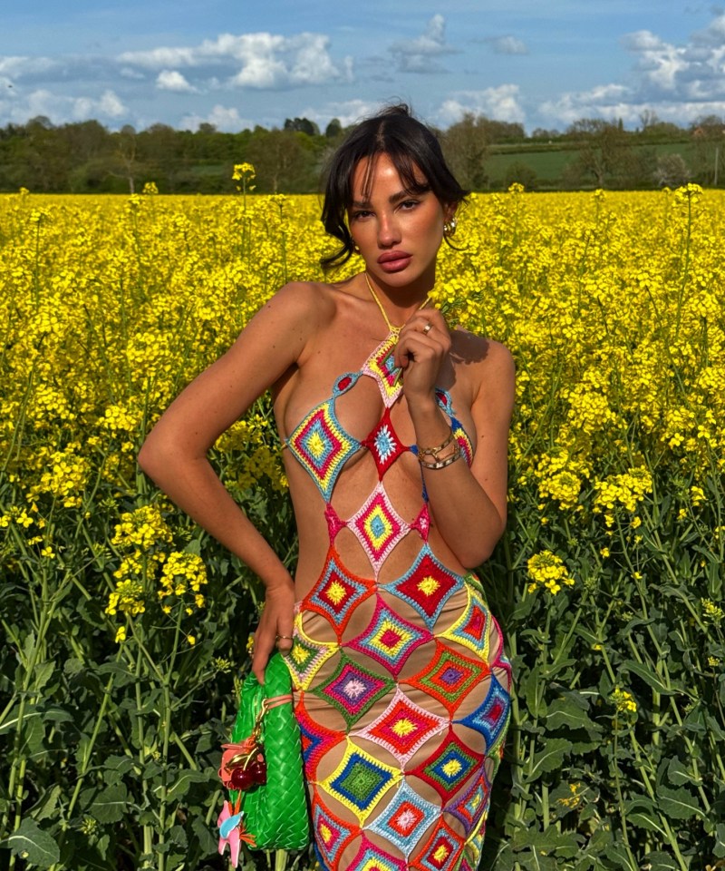 Woman in colorful crochet dress in a field of yellow flowers.