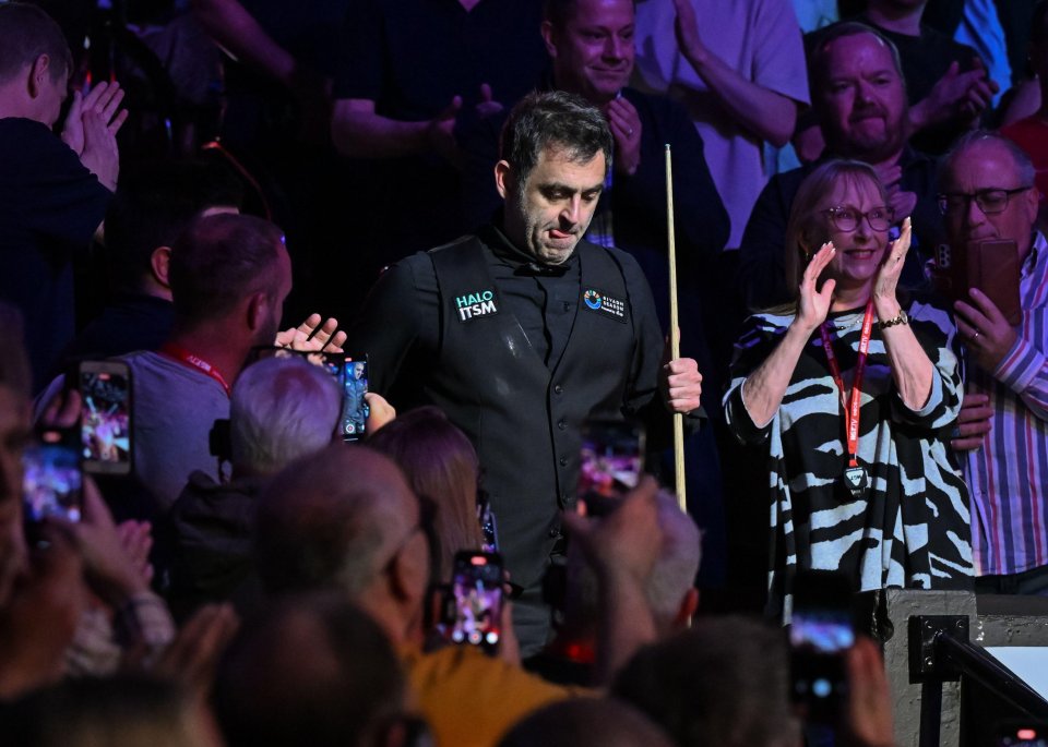 Ronnie O'Sullivan walking onto the stage before a snooker match.