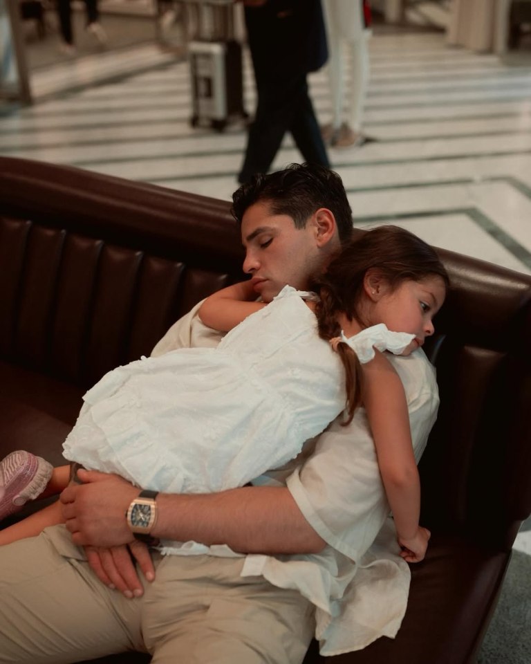 A man and young girl sleeping on a couch.