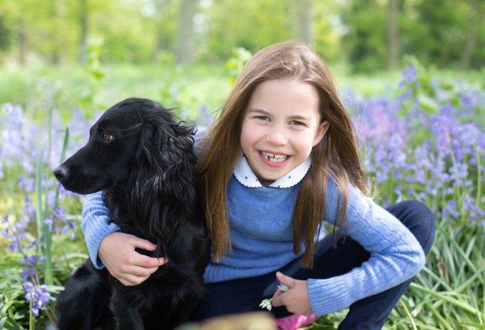 Princess Charlotte hugging her black cocker spaniel.