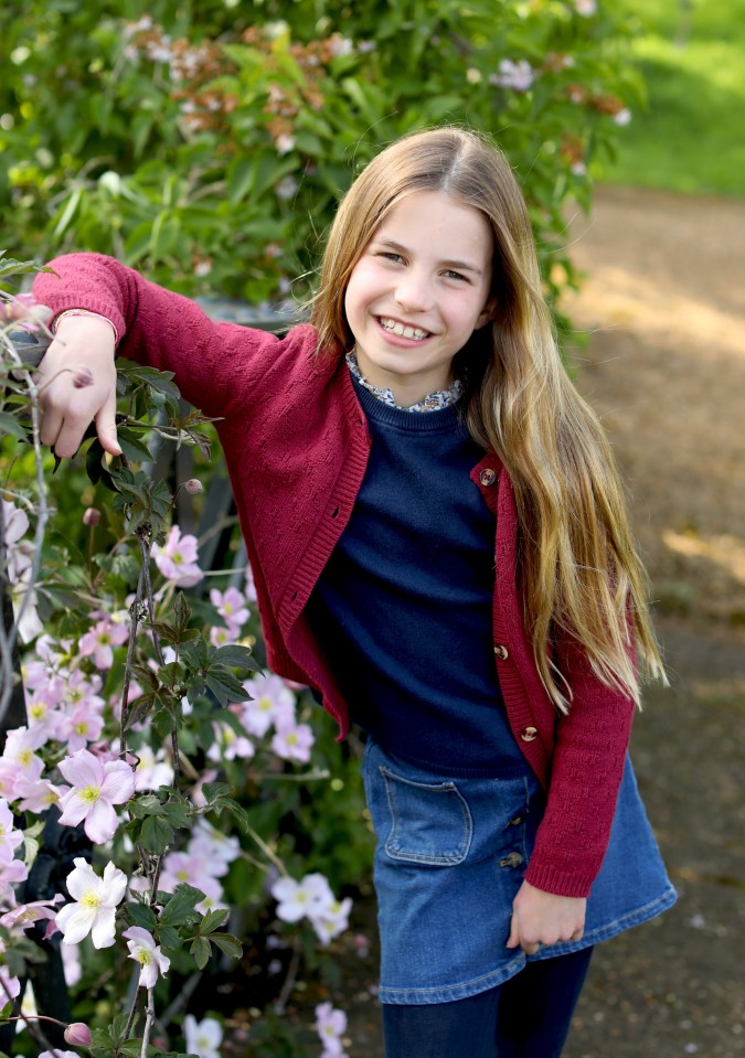 Photo of Princess Charlotte smiling near flowers.
