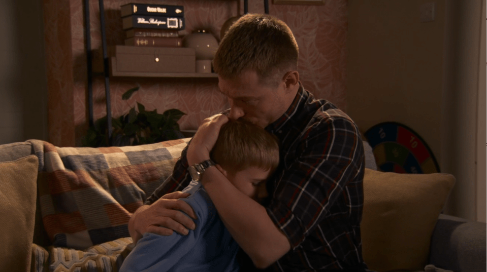 Man comforting a young boy.