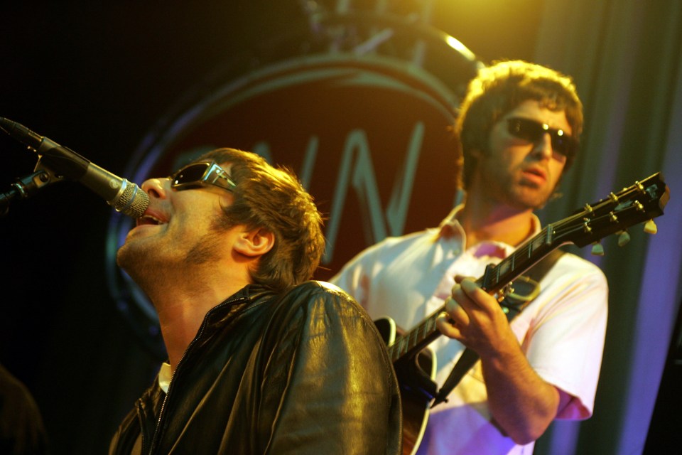 Noel and Liam Gallagher performing onstage.