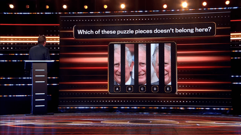Screenshot of a game show screen displaying a puzzle:  Which of five images of King Charles III doesn't belong?